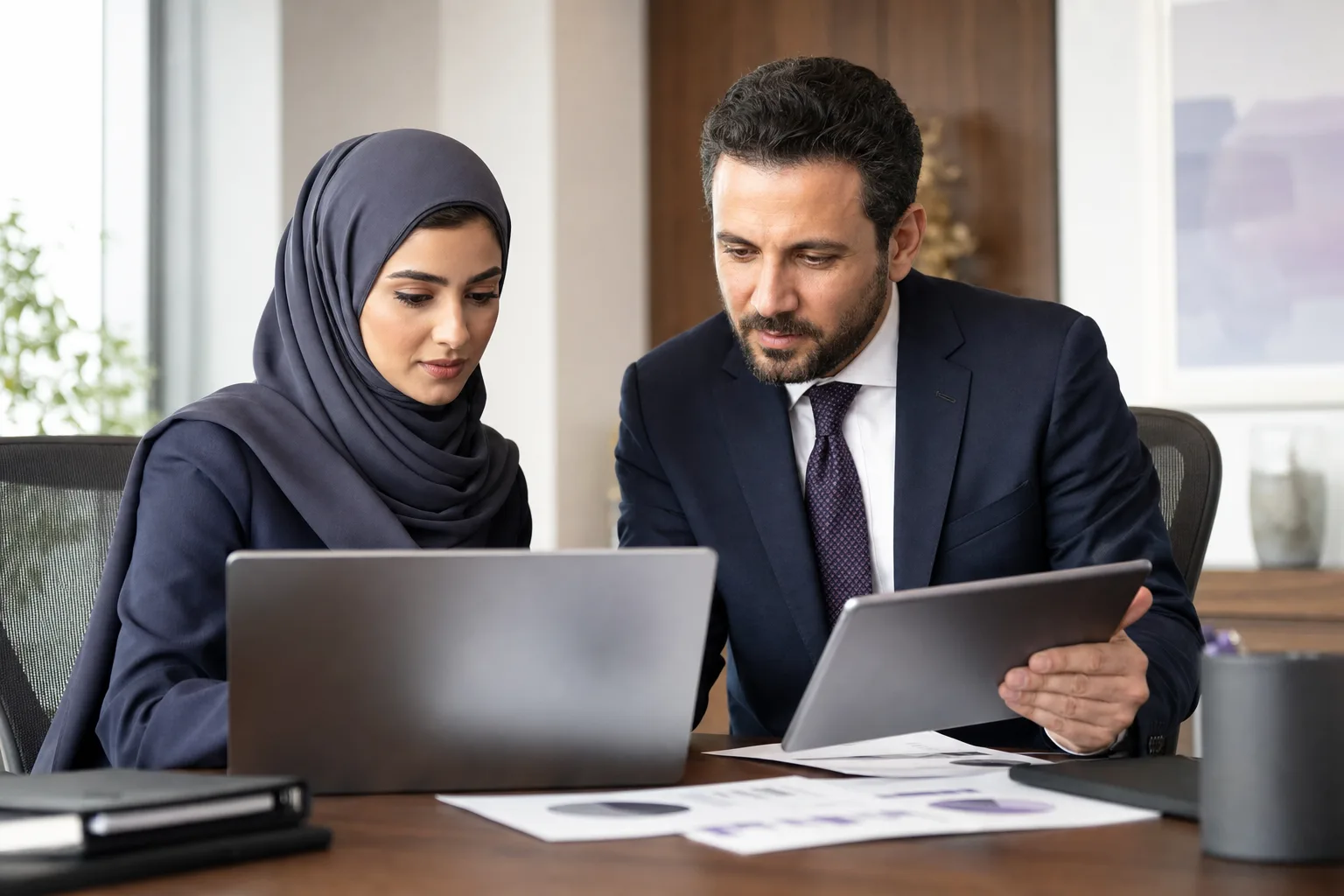 Finance manager and ERP consultant reviewing reports